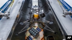 Foto yang dirilis oleh NASA ini menunjukkan wahana pendarat bulan terbaru buatan perusahaan Intuitive Machines yang terpasang pada roket Falcon milik SpaceX. (Foto: NASA via AP)