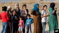 Warga Suriah yang mengungsi akibat operasi militer Turki di timur lau Suriah antre untuk menerima bantuan makanan di kamp pengungsi Bardarash, utara Mosul, Irak, 17 Oktober 2019.