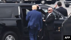 TOPSHOT - Former US President and 2024 hopeful Donald Trump disembarks his plane "Trump Force One" on arrival at Ronald Reagan Washington National Airport in Arlington, Virginia, on August 3, 2023.