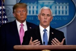 President Donald Trump listens as Vice President Mike Pence speaks during a news conference about coronavirus in the Brady Press Briefing Room of the White House, Feb. 26, 2020, in Washington.