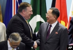 FILE - U.S. Secretary of State Mike Pompeo greets North Korea's Foreign Minister Ri Yong Ho as they prepare for a group photo at the 25th ASEAN Regional Forum Retreat in Singapore, Aug. 4, 2018.