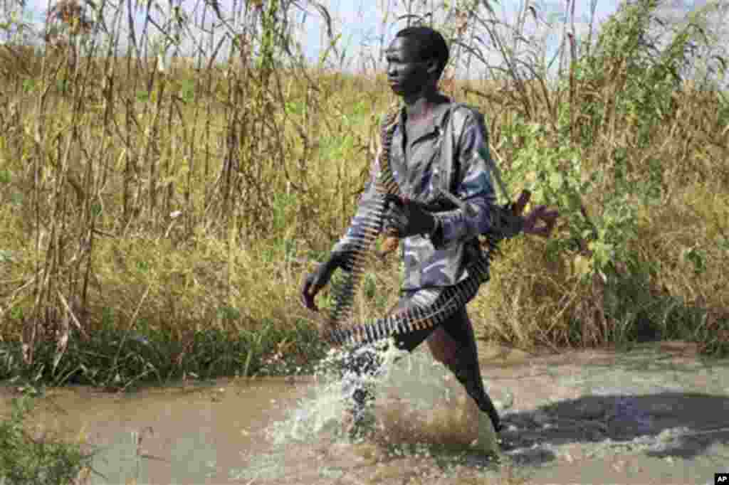 Un rebelle patrouille à travers l’ead d’inondation près du village de Bentiu, au Soudan du Sud le lundi 20 septembre 2014. Seyoum Mesfin, conduisant la mediation au Sud Soudan a declare samedi que les combats ont repris entre l’armée gouvernementale et les rebelles.