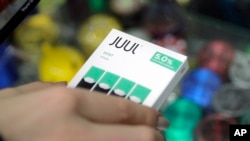 Seorang perempuan membeli kemasan isi ulang rokok elektrik Juul di sebuah toko di New York, 20 Desember 2018.