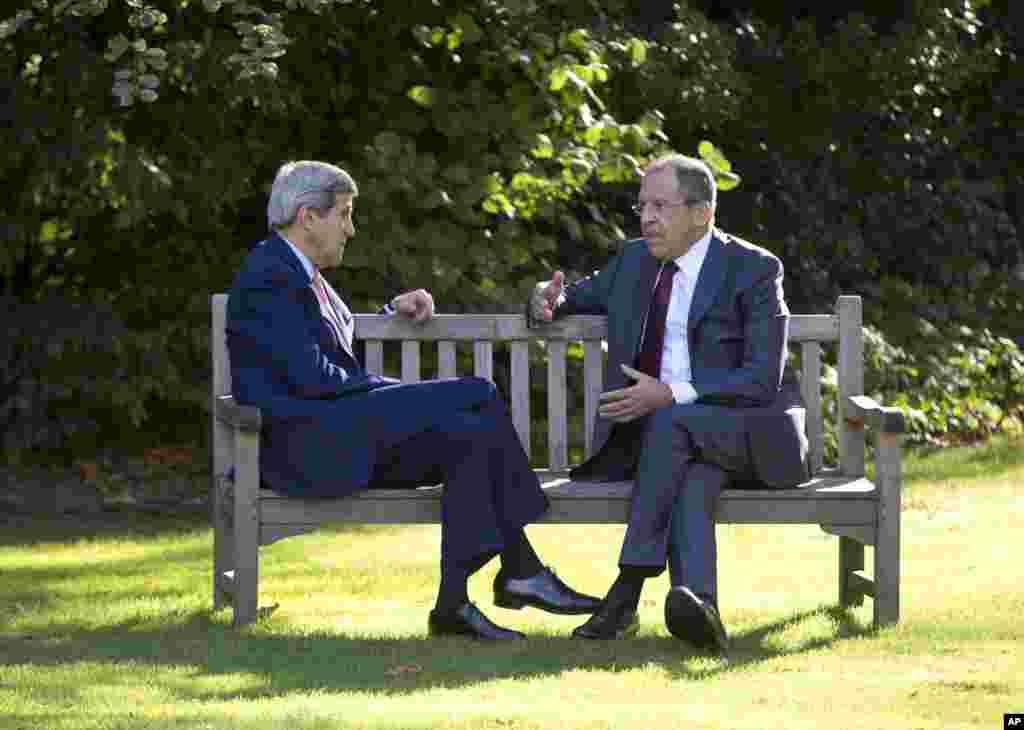 U.S. Secretary of State John Kerry and Russian Foreign Minister Sergey Lavrov sit together on the grounds of the Chief of Mission Residence in Paris, France, Oct. 14, 2014.