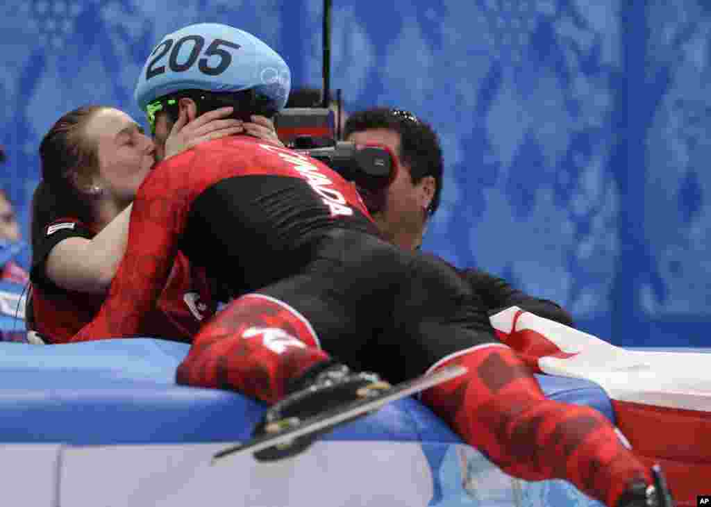 Charles Hamelin of Canada, right, embraces Marianne St. Gelais after he won the men's 1500m short track speedskating final at the Iceberg Skating Palace, Sochi, Russia, Feb. 10, 2014.