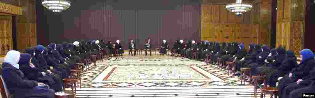 Foto dari Kantor Berita Suriah menunjukkan Presiden Suriah Bashar al-Assad berbicara dengan imam perempuan dari masjid di Damascus dan sekitarnya dan para pendidik agama di sekolah dan institusi di Damascus, 14 Januari 2014.