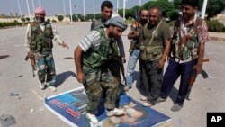 Seorang anggota Laskar Pembebasan Suriah (FSA) menginjak gambar Presiden Bashar al-Assad di kota Tal Abyad dekat perbatasan Turki (foto: dok). 