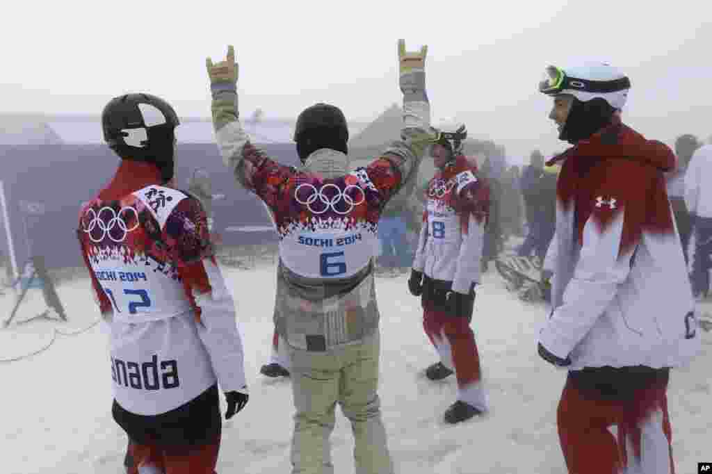 Nick Baumgartner dari AS bercanda dengan atlet-atlet Kanada selagi menanti dimulainya kompetisi cross snowboarding yang kemudian dibatalkan karena kabut di Taman Rosa Khutor, 17 Februari 2014.&nbsp;