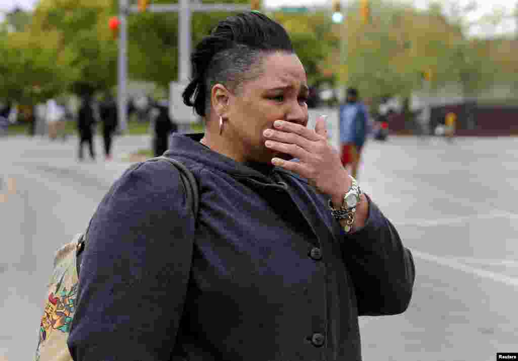 A woman cries as demonstrators throw rocks at Baltimore police during clashes in Baltimore, Maryland, April 27, 2015.
