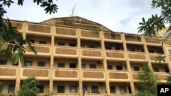 Thai police stand on the balcony outside of an apartment building in Nong Jok on the outskirts of Bangkok, Aug. 29, 2015. Thai police say they arrested a suspect in the blast at the Erawan Shrine in this apartment building.