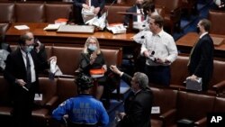 Members of Congress prepare to evacuate the floor as protesters try to break into the House Chamber at the U.S. Capitol, in Washington, Jan. 6, 2021. 