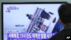 Seorang pria di Seoul menonton berita televisi yang menunjukkan tenggelamnya kapal penumpang di Korea Selatan (16/4). (AP/Ahn Young-joon)