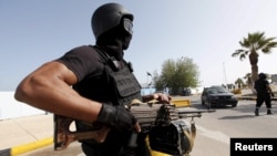 Un agent des forces de sécurité libyenne assure la sécurité à l'entrée du siège du gouvernement de l’union à Tripoli, Libye, 14 avril 2016. 