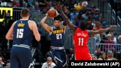 Le pivot des Nuggets Nikola Jokic, à gauche, son coéquipier Jamal Murray, et Jrue Holiday des Pelicans, Denver, le 29 octobre 2018. (AP Photo/David Zalubowski)