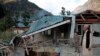 Pakistani Kashmiri residents look at the destruction reportedly caused by artillery fired by Indian forces in Neelum Valley along the Line of Control in Pakistani Kashmir, Oct. 21, 2019.