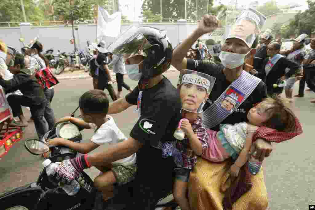 A family takes part in a rally to mark the World Women's Day, in Phnom Penh, Cambodia, March 8, 2013. 