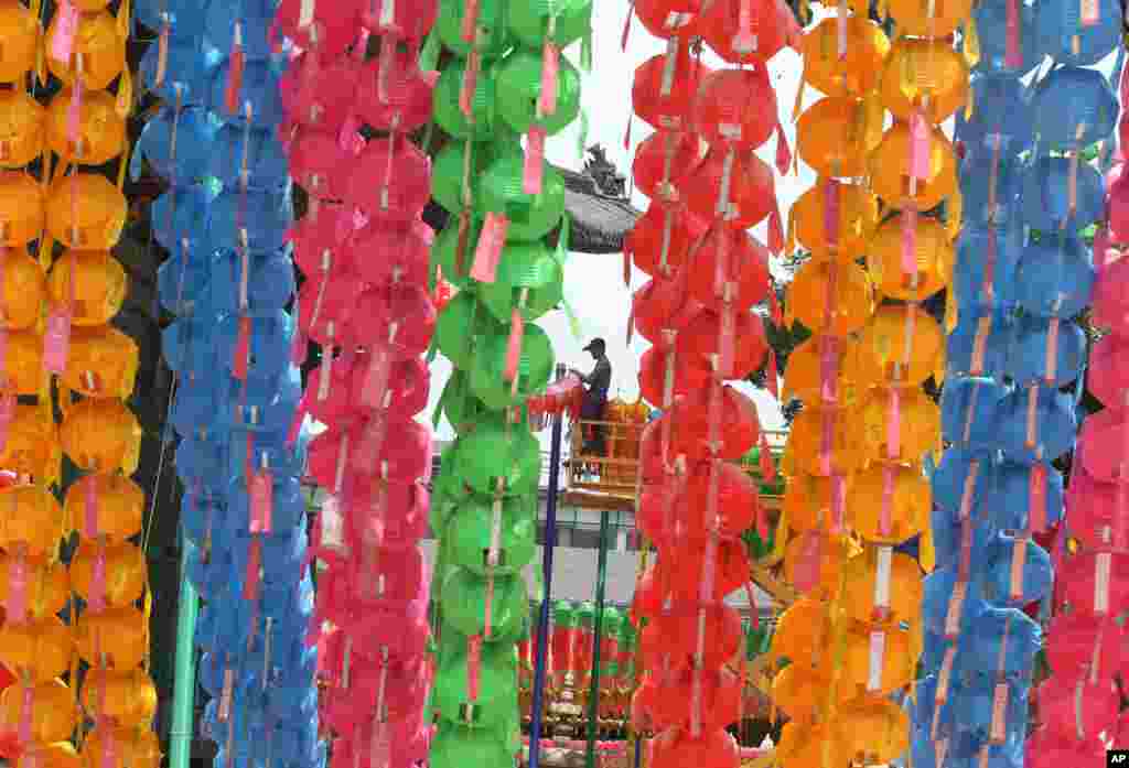 A worker removes lanterns following Buddha's birthday celebrations at the Chogye Temple in Seoul, South Korea. Similar lanterns are annually displayed in all Buddhist temples around South Korea for the public viewing.