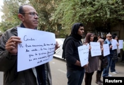 Activists hold placards that read, among others, "Giulio, one of us and killed like us," during a memorial for Giulio Regeni outside of the Italian embassy in Cairo, Egypt, Feb. 6, 2016.