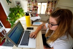 Kelly Mack works on her laptop to teach remotely Sept. 2, 2020, in Evanston, Illinois.