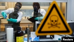 Para pekerja OPCW melakukan pengujian di laboratorium sampel yang terkontaminasi oleh bahan kimia semacam gas Sarin (foto: dok). 