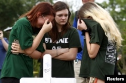 Mourners gather at a makeshift memorial left in memory of the victims killed in a shooting at Santa Fe High School in Santa Fe, Texas, May 21, 2018.
