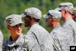 FILE – A female U.S. Army captain smiles as she stands in formation during an Army Ranger School graduation ceremony at Fort Benning, Georgia, Aug. 21, 2015.