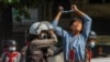 FILE - A pro-democracy protester is detained by riot police during a rally against the military coup in Yangon, Myanmar, Feb. 27, 2021.