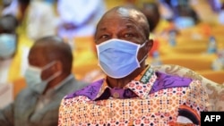 Le président guinéen Alpha Condé, portant un masque protecteur, participe à la convention RPG de son parti à Conakry avant l'élection présidentielle du pays le 6 août 2020 (Cellou Binani/AFP)