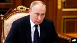 In this Jan. 18, 2022, photo, Russian President Vladimir Putin listens during a meeting in the Kremlin, in Moscow, Russia. 