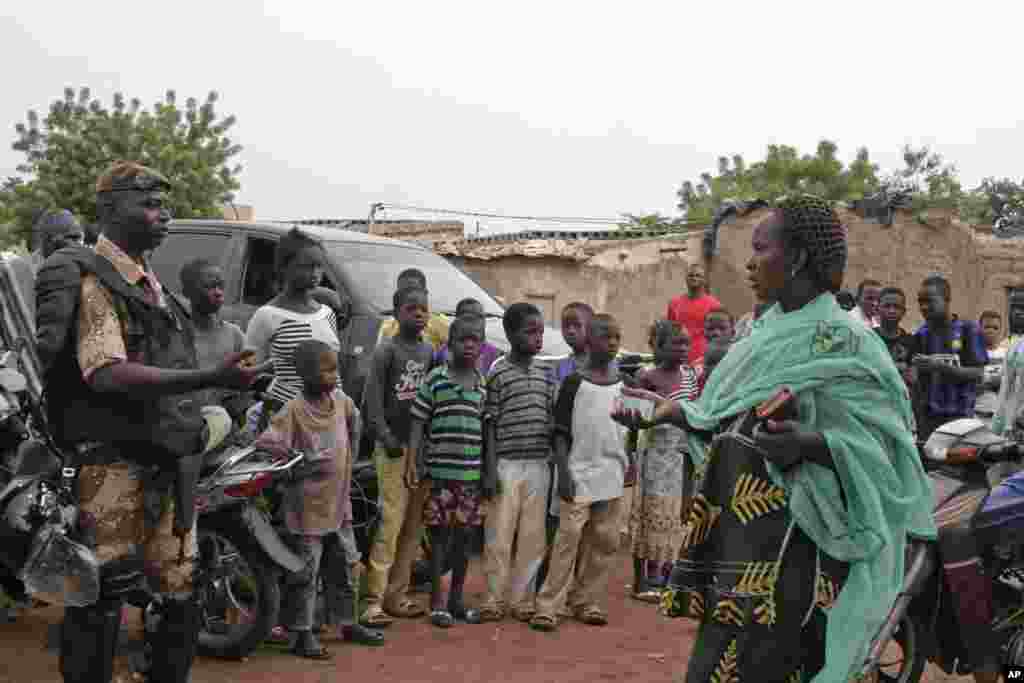 A Malian woman with her voting card in her hand goes to cast her vote in Bamako, Mali, July 28, 2013. 