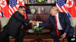 지난달 12일 도널드 트럼프 미국 대통령과 김정은 북한 국무위원장이 싱가포르 카펠라 호텔의 단독회담장에 입장한 후 다시 악수를 하고 있다. 두 정상은 사진 촬영 후 비공개로 회담을 진행했다.