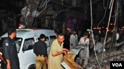 Warga Pakistan berusaha mencari para korban di lokasi serangan bom kembar di kota Peshawar (11/6).