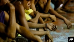 Warga yang ditangkap kebanyakan laki-laki, menunggu untuk dibawa ke kantor polisi dalam pelaksanaan operasi dari kampanye "Perang Terhadap Narkoba" Presiden Rodrigo Duterte, di komunitas kumuh Tondo, di Manila, Filipina, 30 September, 2016. (Foto: dok).