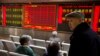Investors gather near a display board showing the plunge in the Shanghai Composite Index at a brokerage in Beijing, China, Thursday, Jan. 7, 2016.