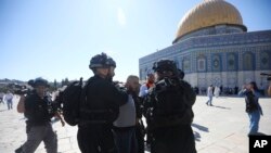 Israeli police arrests a Palestinian worshipper at al-Aqsa mosque compound in Jerusalem, Aug. 11, 2019.