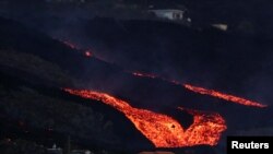 Lava from the Cumbre Vieja volcano flows behind houses in Los Llanos on the Canary Island of La Palma, October 13, 2021.