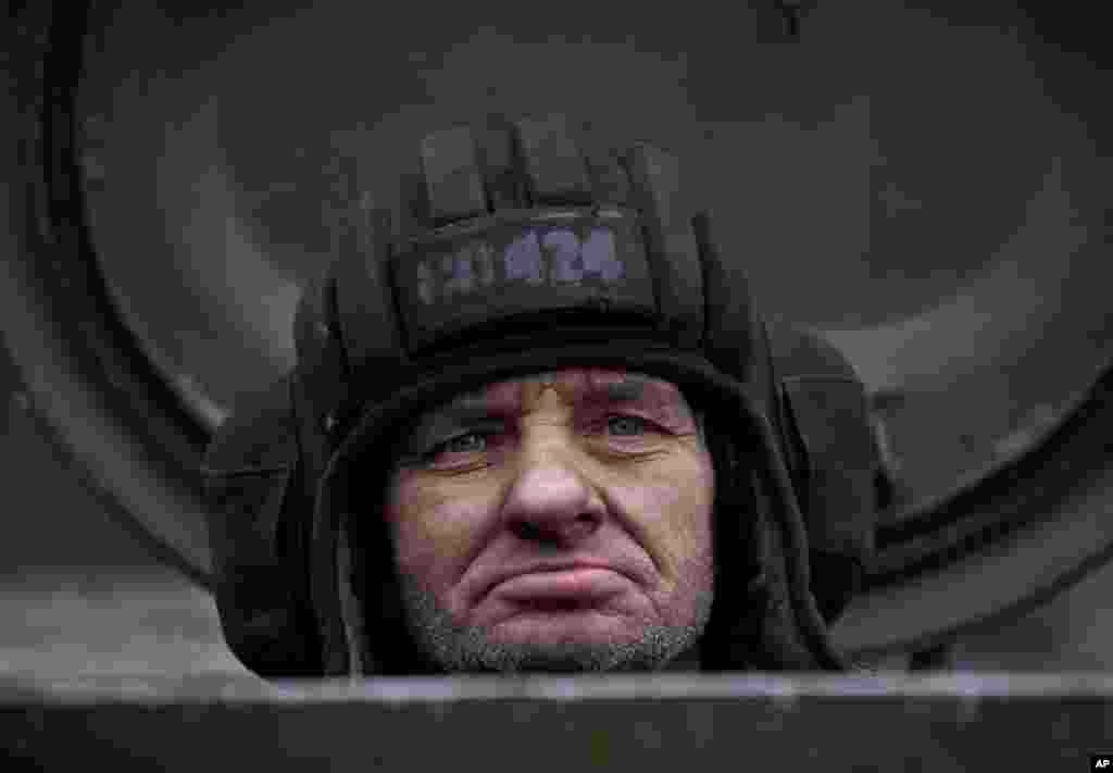 A Russia-backed separatist fighter sits in a self-propelled 152 mm artillery piece, part of a unit that moved away from the front lines, in Yelenovka, near Donetsk, Feb. 26, 2015.