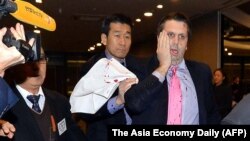 Dubes AS untuk Korea Selatan Mark Lippert (kanan) menutupi wajahnya yang luka kena tikaman di Seoul F( 5/3). 