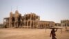 FILE - A man carries a table as he walks past the ruins of a building in the port city of Massawa, Eritrea, July 22, 2018. 