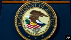 FILE - Nov. 28, 2018 photo, the Department of Justice seal in Washington, D.C. An internet firm is ending the automated registration of website names that include words related to the COVID-19 pandemic, in an attempt to combat coronavirus-related fraud.