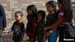 Children form a line as undocumented immigrant families are released from detention at a bus depot in McAllen, Texas, June 22, 2018. Experts say being separated from their parents can take a heavy toll on children.