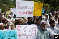 FILE - Mohammad Idrees (foreground 2nd-R), father of accident victim Ateeq Baig, sits with people gathered at the spot where 22-year-old Baig was killed and another person injured when the U.S. military attaché Col. Joseph Emanuel Hall allegedly ran a red light and hit his motorcycle last week, in Islamabad, Pakistan, Friday, April 13, 2018.