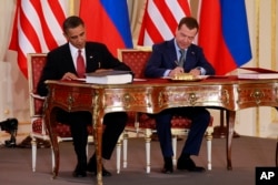 FILE - President Barack Obama, left, and Russian president Dmitry Medvedev sign the New START treaty at the Prague Castle in Prague in this, April 8, 2010 file photo.