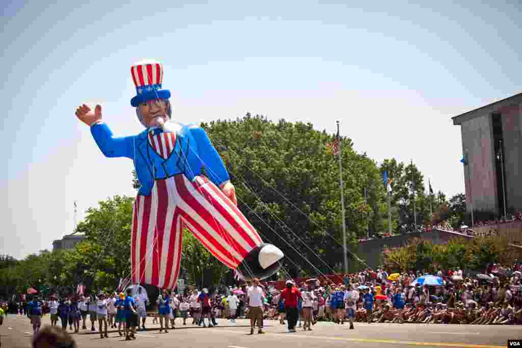 Sebuah boneka tiup Paman Sam raksasa ikut meramaikan parade tahunan Hari Kemerdekaan Amerika di pusat kota Washington, DC, 4 Juli 2012. (Allison Klein / VOA) 