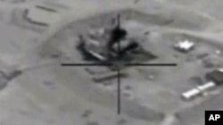In this framegrabbed image provided by the U.S. Department of Defense shows airstrike footage on the Jeribe West Refinery in Syria Wednesday Sept. 24, 2014. 
