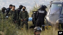 Soldiers stand guard as federal police officers carry a stretcher with the body of a victim of a helicopter crash in which Mexico's Interior Minister Francisco Blake Mora and seven others were killed near Mexico City, November 11, 2011.