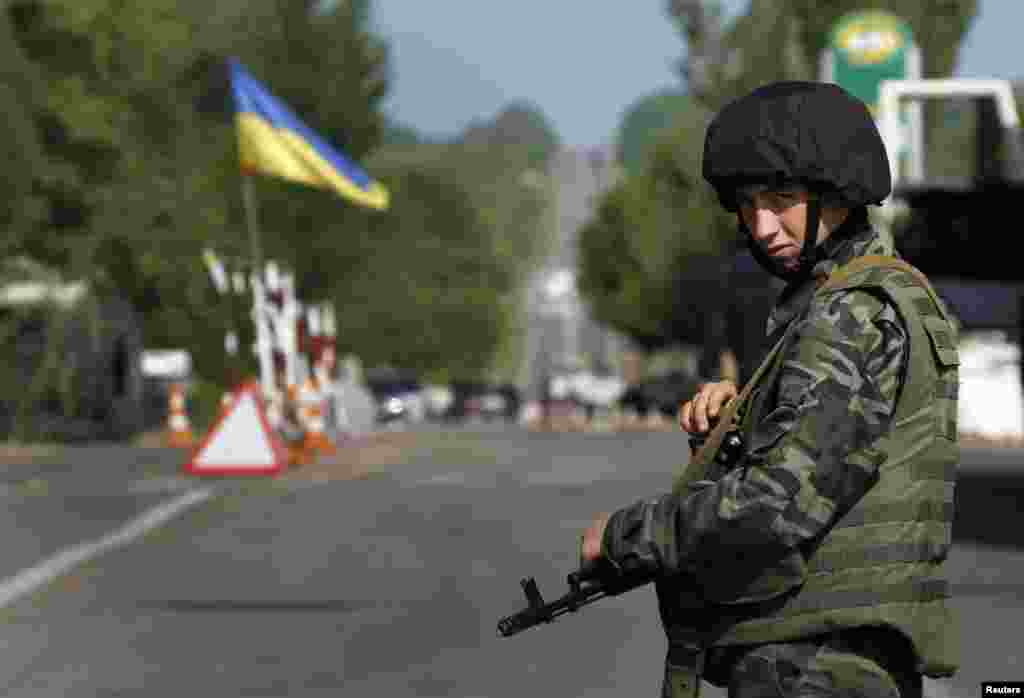 Seorang tentara Ukraina menjaga jalan yang diblokir di bagian utara kota Slovyansk, Ukraina timur (13/5). (Reuters/Yannis Behrakis)