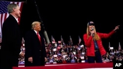 FILE - Sen. Kelly Loeffler, R-Ga., speaks as President Donald Trump and Sen. David Perdue, R-Ga., listen at a campaign rally at Valdosta Regional Airport in Georgia, Dec. 5, 2020.