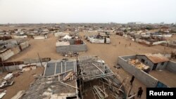 People walk in a shantytown near the port of Hodeida, Yemen, June 16, 2018.