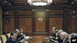 Russian President Dmitry Medvedev, left, speaks to US Defense Secretary Robert Gates, second right, during their meeting at which they discussed the planned missile defense system in Europe, at the Gorki residence outside Moscow, March 22, 2011